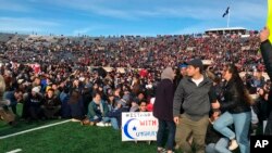 Demonstrators stage a protest on the field at the Yale Bowl disrupting the start of the second half of an NCAA college football game between Harvard and Yale, in New Haven, Connecticut, Nov. 23, 2019.