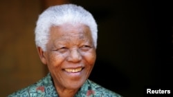 FILE - Former South African president Nelson Mandela smiles for photographers at his home in Johannesburg September 22, 2005.