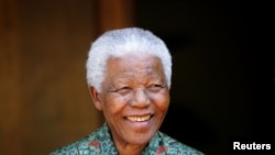FILE - Former South African president Nelson Mandela smiles for photographers at his home in Johannesburg September 22, 2005.