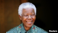 FILE - Former South African president Nelson Mandela smiles for photographers at his home in Johannesburg on September 22, 2005.