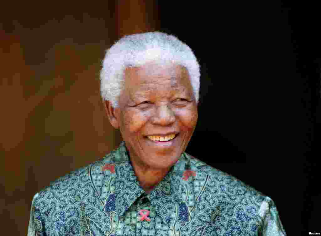 Nelson Mandela smiles for photographers at his home in Johannesburg September 22, 2005.