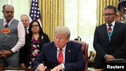 U.S. President Donald Trump signs an Executive Order to address the issue of missing and murdered Native Americans in the Oval Office at the White House in Washington, Nov. 26, 2019.