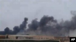A plume of smoke rising over the skyline in Ajdabiya, eastern Libya, the last major city between forces loyal to Libyan leader Moammar Gadhafi and rebel-held Benghazi.