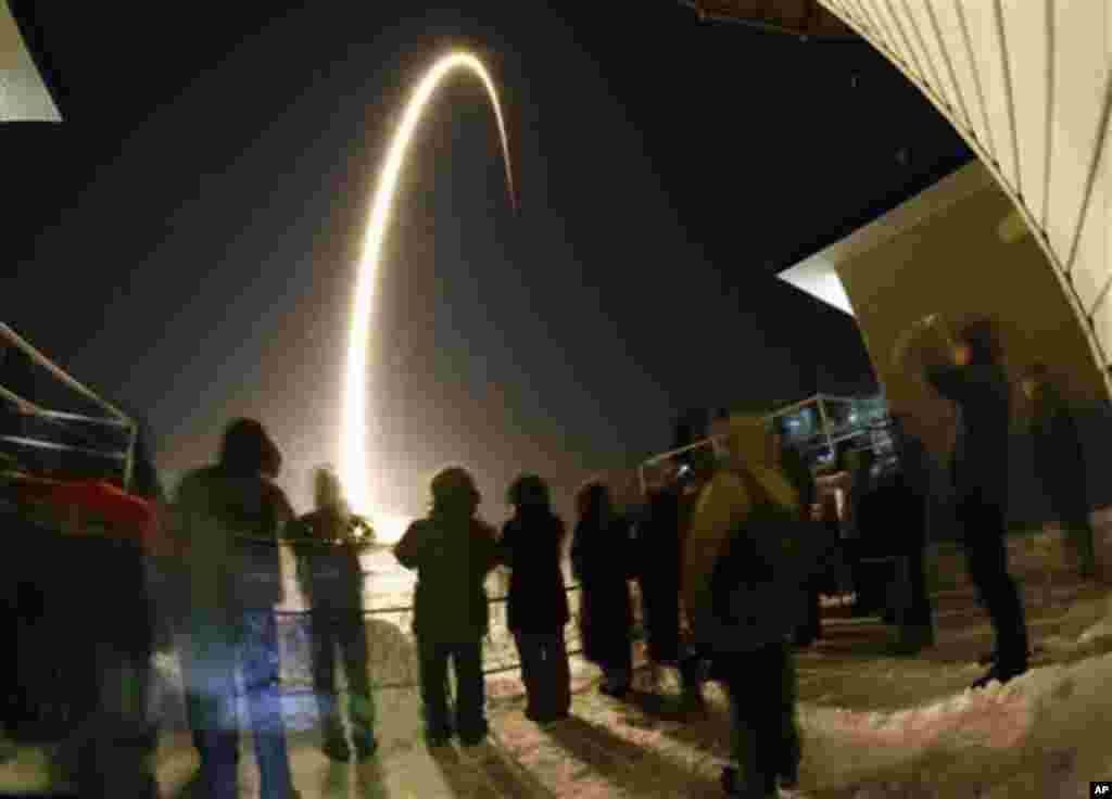 In this photo taken with a fisheye lens and with long time exposure, people lwatchthe launch of the Soyuz-FG rocket booster with the Soyuz TMA-03M space ship carrying a new crew to the International Space Station, ISS, at the Russian leased Baikonur cosmo