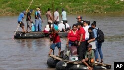 Para migran menyeberangi sungai dari Tecun Uman, Guatemala ke wilayah Meksiko untuk selanjutnya menuju ke Amerika Serikat, Senin 7 Juni 2021. 