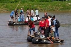 Orang-orang menggunakan rakit untuk menyeberang di Sungai Suchiate, antara Ciudad Hidalgo, Mexico (atas) dan Tecun Uman, Guatemala, Senin, 7 Juni 2021.