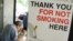 FILE - A man has his lunch behind a poster demarcating a No-Smoking zone in Singapore, June 28, 2006. 