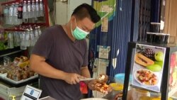 Ben Lim prepares his family fruit shop’s popular rojak salad. Lim says business is down almost 40-percent in just the past week. (Dave Grunebaum/VOA)