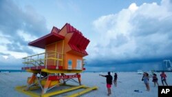 Bañistas en South Beach, Florida, revisan uno de los puestos de salvavidas en anticipo a la llegada del huracán Dorian. Agosto 30 de 2019. AP/Wilfredo Lee.