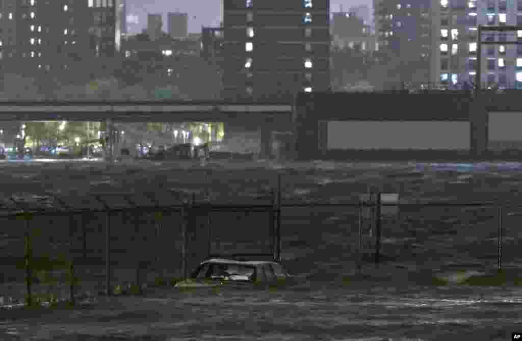 A car is submerged in the Dumbo section of the Brooklyn borough of New York, as the East River overflows during hurricane Sandy, on Oct. 29, 2012. 