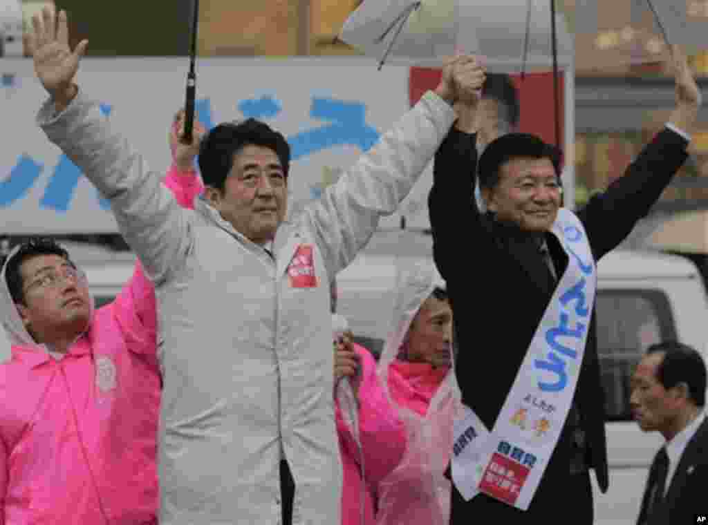 Japan's main opposition Liberal Democratic Party (LDP) President Shinzo Abe, left, and the party's candidate Yoshitaka Shindo acknowledge crowd during a campaign rally for the Dec. 16 parliamentary elections in Kawaguchi, near Tokyo, Saturday, Dec. 15, 20