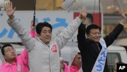 Pemimpin Partai Oposisi Jepang, partai Demokratik Liberal (LDP) Shinzo Abe (kiri) dan kandidar partai Yoshitaka Shindo melambaikan tangannya di hadapan para pendukungnya dalam kampanye untuk pemilu Parlemen Jepang, di Kawaguchi, dekat Tokyo, Sabtu (15/12). Pemilu parlemen akan dilaksanakan hari Minggu , 16 Desember 2012.