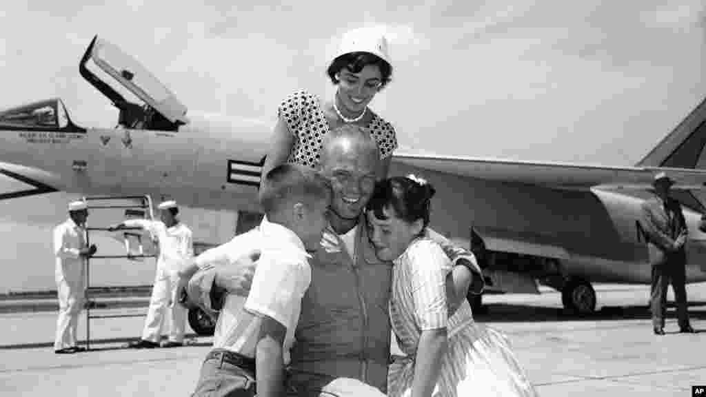 Major John Glenn Jr., hugs his children, Dave and Lyn, while his wife, Anne, watches moments after Glenn landed at Floyd Bennett Field in New York following his record-breaking flight of just over 3 hours and 23 minutes from California, July 16, 1957.