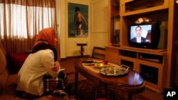 Iranian woman Marzieh Masaebi watches a TV video showing US President Barack Obama's new video message addressed to the Iranian people, and broadcast from the Tapesh Farsi-language satellite TV beamed in from the United States, at her home in Tehran, Iran.