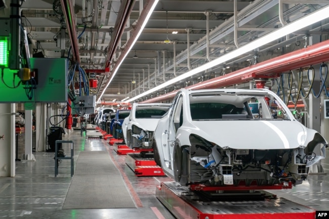 FILE - Cars are seen on the assembly line during a tour of the Tesla Giga Texas manufacturing facility ahead of the "Cyber Rodeo" grand opening party on April 7, 2022 in Austin, Texas. (Photo by SUZANNE CORDEIRO / AFP)