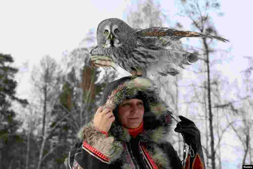 Mykh, a two-year-old Great Gray Owl, sits on the head of ornithologist Daria Koshcheyeva during a training session. It is part of a project by a local zoo to tame wild animals for further research and interaction with visitors, in the Siberian Taiga forest in Krasnoyarsk, Russia.