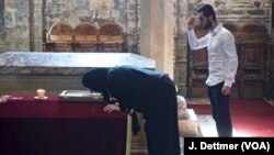 Serbs pray before the tomb of "holy king" Stefan Dečanski. The church and monastery of Visoki Dečani is protected by soldiers from the NATO-led international peacekeeping force, KFOR. The monastery has been attacked several times since the end of the Kosovo War, the last time in 2007.