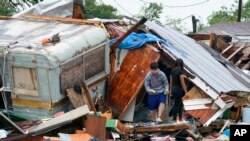 Orang-orang menyelamatkan barang-barang dari puing-puing rumah mereka setelah tornado melanda kawasan permukiman di Laguna Heights, Texas. 