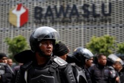 Anggota Brimob menjaga ketat kantor pusat Badan Pengawas Pemilu (Bawaslu) saat berlangsungnya aksi protes menyusul pengumuman hasil resmi pemilu di Jakarta, 22 Mei 2019. (REUTERS)