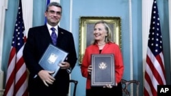 Secretary of State Hillary Rodham Clinton and Romania's Foreign Minister Teodor Baconschi shows the bilateral agreement between US and Romania on the deployment of Ballistic Missile Defense System in Romania.