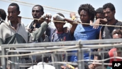 Những người di cư đang chờ được đưa lên bờ từ tàu hải quân tại cảng Catania, Ý, hôm 16/6/2015.