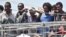 Migrants wait to be disembarked from the Irish Navy ship P31 L.E. Eithne at the Catania harbor, Italy, June 16, 2015. 