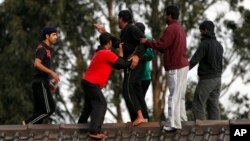 FILE - In this Sept. 21, 2010 file photo, asylum seekers stop a fellow detainee from jumping off the Villawood Detention Center roof in Sydney, Australia, during a protest by the detainees who say they are scared of being returned to their home countries 