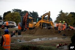 Workers dig graves at a Muslim cemetery in Christchurch, New Zealand, March 17, 2019, for victims of a mass shooing at two area mosques.