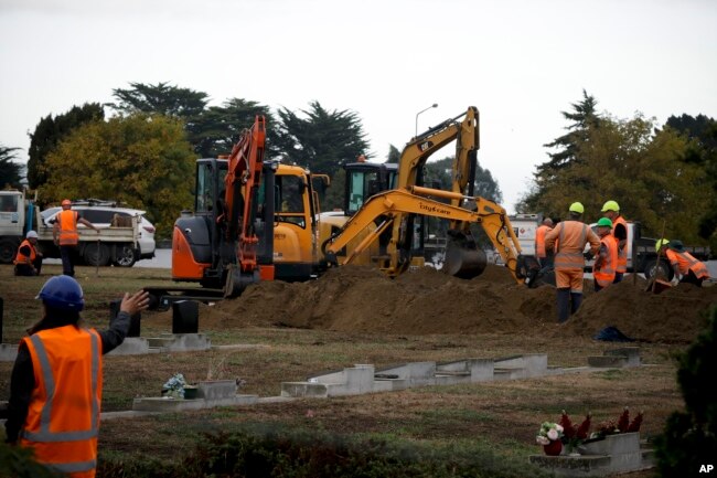 Workers dig graves at a Muslim cemetery in Christchurch, New Zealand, March 17, 2019, for victims of a mass shooing at two area mosques.