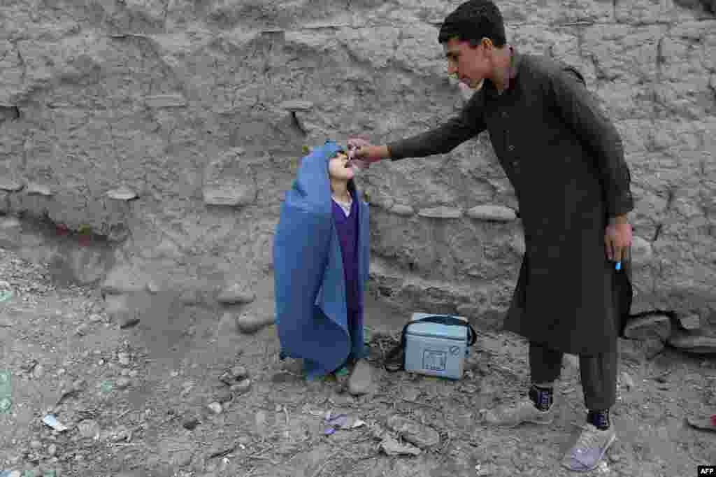 A health worker administers the polio vaccine to a child during a vaccination campaign on the outskirts of Jalalabad, Pakistan.