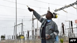 Un ingénieur pointant vers des lignes à haute tension à la centrale thermique d'Azito près d'Abidjan, le 14 septembre 2016.