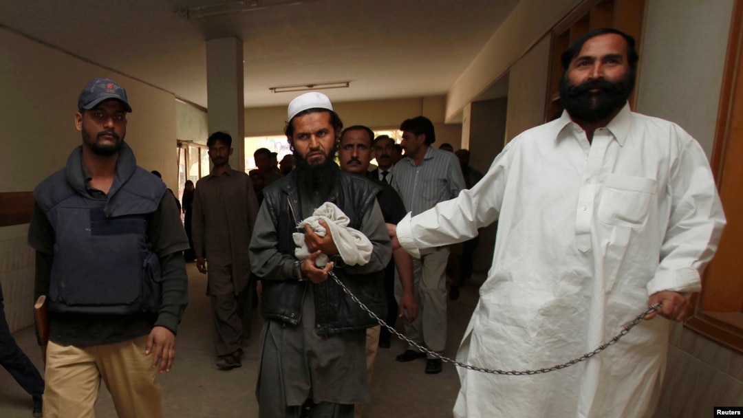 FILE - Police escort a man, identified as Afghan Taliban's top military commander, Mullah Abdul Ghani Baradar.
