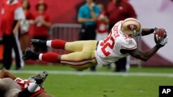 Kendall Hunter, de los 49ers de San Francisco, se lanza para anotar en el triunfo sobre los Bucaneros, 33 a 14.