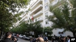 Media stand outside the Swiss Embassy after an explosion in Athens, 02 Nov 2010