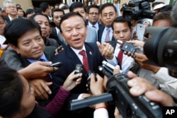 FILE - Cambodia's main opposition Cambodia National Rescue Party Deputy President and National Assembly Deputy President Kem Sokha, center, speaks to reporters outside the Phnom Penh Municipality Court in Phnom Penh, Cambodia, April 8, 2015.