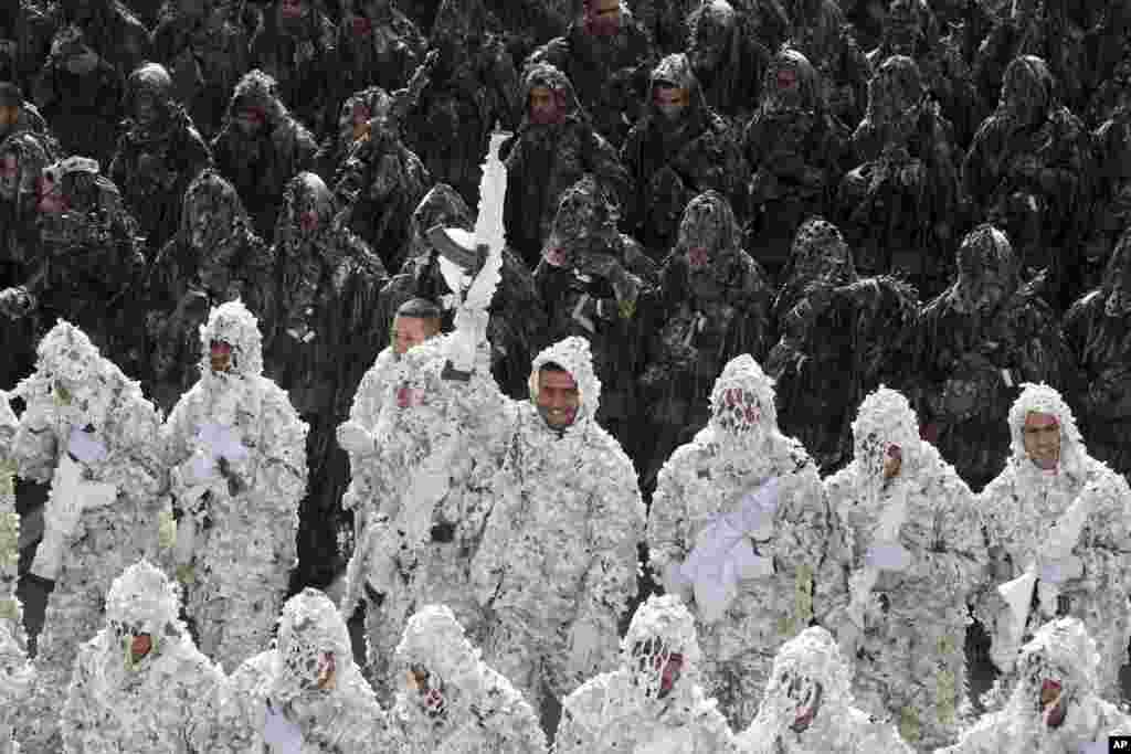 Wearing ghilli suits, Iranian army troops march in a parade as one of them hold up his weapon, marking National Army Day in front of the mausoleum of the late revolutionary founder Ayatollah Khomeini just outside Tehran.