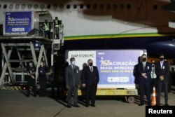 Brazil's Health Minister Eduardo Pazuello, other Brazilian officials and India's ambassador attend a ceremony where 2 million doses of AstraZeneca/Oxford vaccines from India are being transported to Rio de Janeiro at Sao Paulo Airport, Jan. 22, 2021.