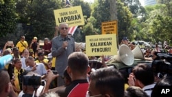 Malaysia's opposition coalition prime ministerial candidate Mahathir Mohamad speaks against a controversial proposal to redraw electoral boundaries outside near the Parliament House in Kuala Lumpur, Malaysia March 28, 2018. The sign (front R) reads: "Go o