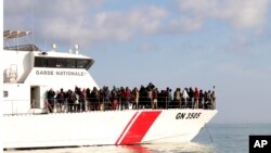 FILE - Migrants board a vessel after getting stopped by Tunisian Maritime National Guard at sea during an attempt to get to Italy, near the coast of Sfax, Tunisia, April 18, 2023. 