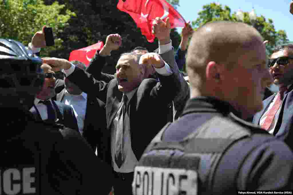 Supporters of Turkish President Recep Tayyip Erdogan react to anti-Erdogan supporters on the other side of a line of police officers outside the White House in Washington, D.C., May 16, 2017.