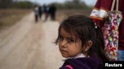 FILE - Alondra Poula, a five-year-old migrant from Nicaragua seeking asylum, walks down a dirt road with her mother after illegally crossing the Rio Grande river into the U.S. from Mexico in Penitas, Texas, Jan. 10, 2019. 