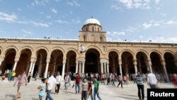 Des Tunisiens marchent devant une mosquée à Tunis, en Tunisie, le 2 juin 2017.