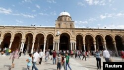 Des Tunisiens marchent devant une mosquée à Tunis, en Tunisie, le 2 juin 2017.