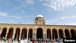 Des Tunisiens marchent devant une mosquée à Tunis, en Tunisie, le 2 juin 2017.