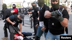 Plain clothes police officers arrest a soccer fan during clashes before the Poland and Russia Group A Euro 2012 soccer match in Warsaw, June 12, 2012.