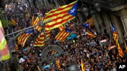 Ribuan pendukung pro-kemerdekaan Catalonia melakukan unjuk rasa merayakan pengumuman kemerdekaan Catalonia di Barcelona, hari Jumat (27/10). Ratusan warga penentang kemerdekaan juga melakukan demonstrasi di Barcelona. 