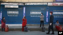국가봉쇄가 내려진 네팔 카트만두에서 마스크를 착용한 시민들이 가정 액화용 가스를 구매하기 위해 줄 서 있다.