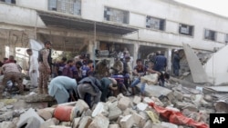 Pakistani security personnel and rescuers inspect the scene of a gas explosion in Karachi, Pakistan, Saturday, Dec. 18, 2021. 