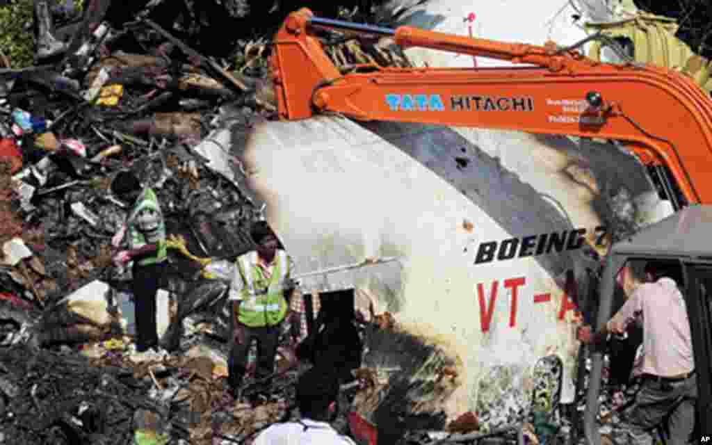 Officials of Air India and the Airports Authority of India work at the plane crash site of the Air India Express Boeing 737-800 and searching for the "black box" data recorder in Mangalore, 24 May 2010