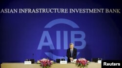 President of Asian Infrastructure Investment Bank (AIIB) Jin Liqun greets to journalists as he arrives at a news conference in Beijing, Jan. 17, 2016.